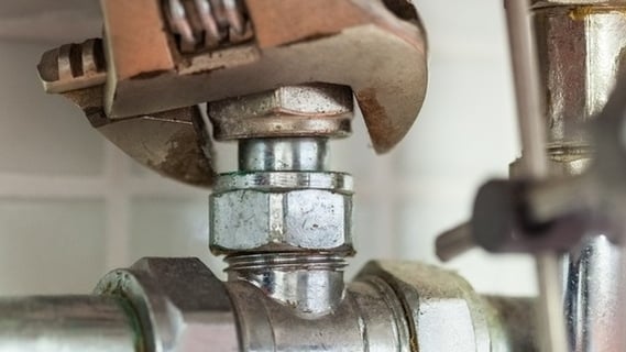 Close up of hand repairing pipes with wrench-910492-edited.jpeg