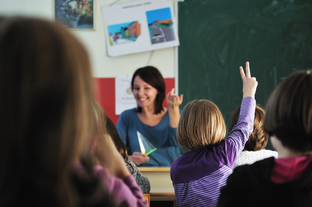 happy young teacher woman at elementary school teaching and giving leassons to group of young smart children.jpeg